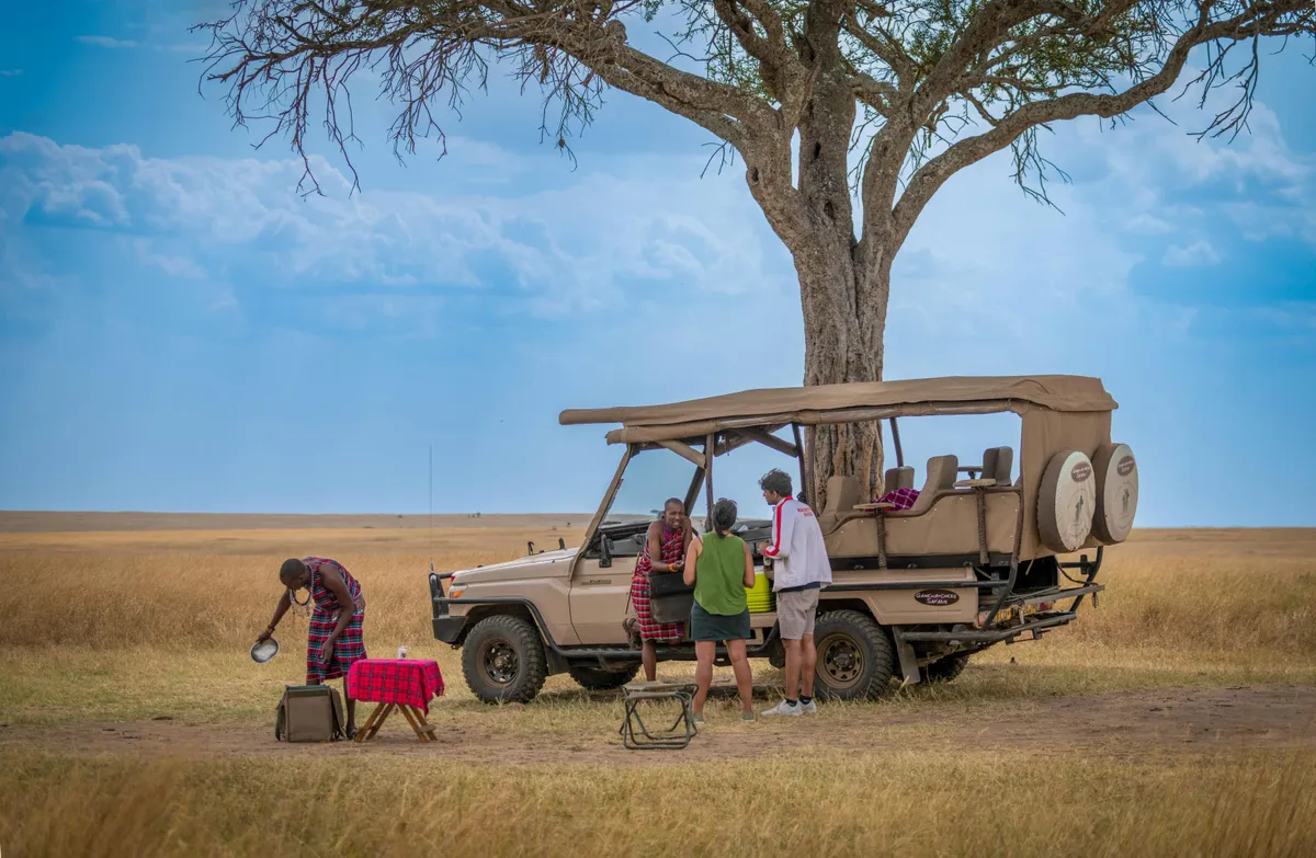 Safari-Jeep unter Akazie in der afrikanischen Savanne